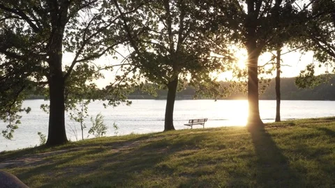 A Lake at Sunset With an Empty Bench (Steadicam) (Ungraded) Stock Footage 76546510