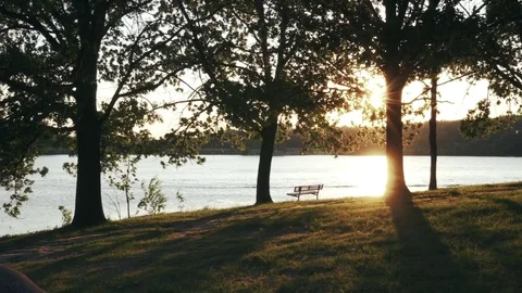 A Lake at Sunset With an Empty Bench (Steadicam) (Graded) Stock Footage 76546511