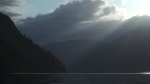Lake at Sunset Over Distant Mountain With Silhouettes of Trees Stock Footage 233470486