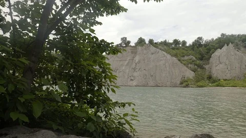 A lake surrounded by cliffs. Slider shot with rocks in the foreground. Stock Footage 77583068