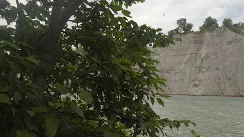 A lake surrounded by cliffs. Slider shot with rocks in the foreground. Stock Footage 77583144