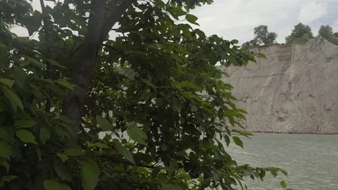A lake surrounded by cliffs. Slider shot with rocks in the foreground. Stock Footage 77583222