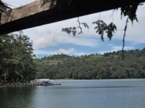 A lake surrounded by mountains against a backdrop of blue sky Stock Footage 274440528