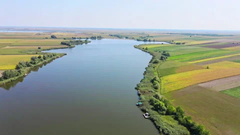 Lake surrounded with multi colored fields captured from above in summer Stock Footage 263087431