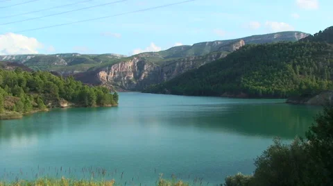 Lake surrounded by pine forests, overhead power lines Stock Footage 50084288