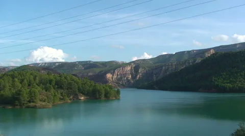 Lake surrounded by pine forests, overhead power lines Stock Footage 50084289