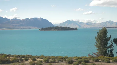 Lake Tekapo with its tree-filled island in the middle, in New Zealand Stock Footage 217399600