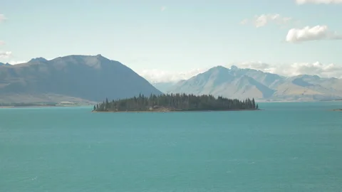 Lake Tekapo with its tree-filled island in the middle, in New Zealand Stock Footage 217399837