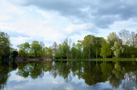 Lake with trees in the background and a cloudy sky Stock Photos