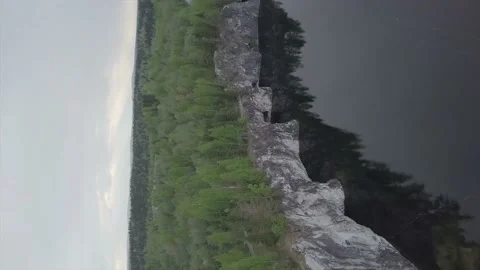 Lake under a cliff with a forest.(vertical video) Stock Footage 149108356