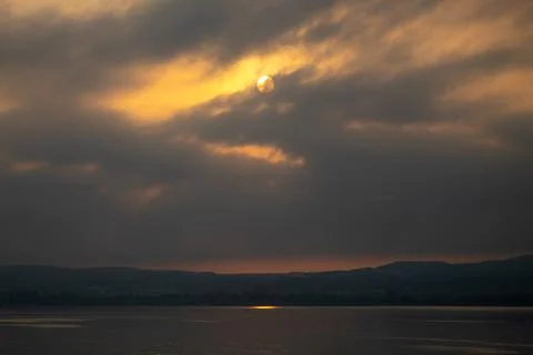 A lake view and gray clouds at sunrise Stock Photos