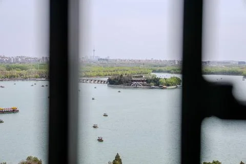 Lake view framed by dark window bars in Beijing Stock Photos
