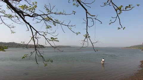Lake view of Goa through Tree Branches. Local guys from goa standing close to th Stock Footage 141326756