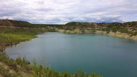 Lake view from a high point in a quarry surrounded by trees on a cloudy day Stock-Footage 340448228