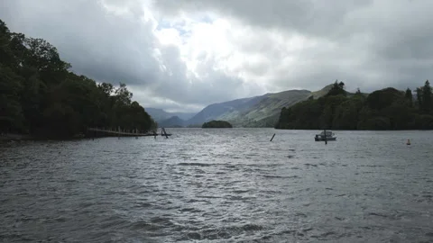 A lake view with a stranded boat and mountains seen in the distance. Stock Footage 254843342