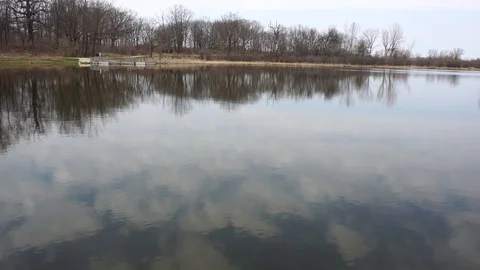 Lake of water in the spring fall with a pier, 4k. Stock Footage 115273765