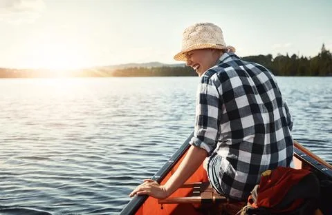 The lake is where she gets away from it all. an attractive young woman spending Stock Photos