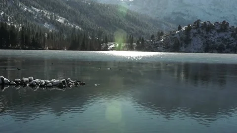 Lake in Winter with Snow Covered Mountains and Low Moving Fog, Lens Flare Stock Footage 145453767