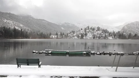 Lake in Winter with Snow Covered Mountains and Boats, Reflection, Gimbal Shot Stock Footage 145453901
