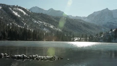Lake in Winter with Snow Covered Mountains, Lens Flare, Low Moving Fog Stock Footage 145455571