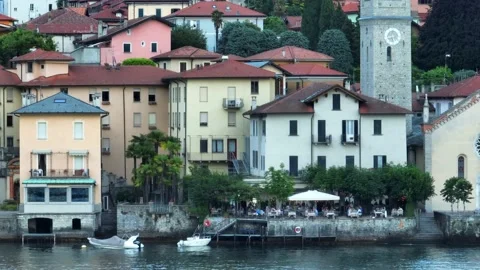 Lakefront terrace dining below a clock tower on Lake Como Stock Footage 198069951