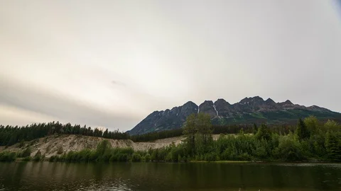 Lakeside mountain time lapse day to night with fast clouds moving under stars Stock Footage 128408140