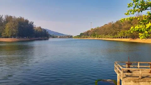 Lakeside View with Platform, Trees, Hotel, and Mountain in Phuket, Thailand Stock Photos
