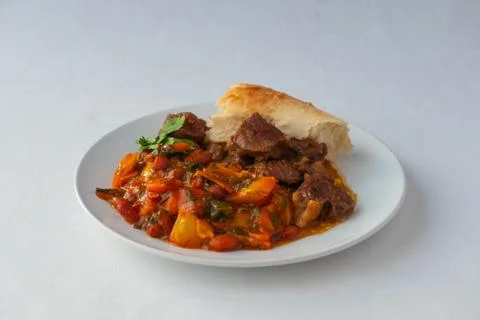 Lamb and vegetable side dish with beans and homemade flatbread. Stock Photos