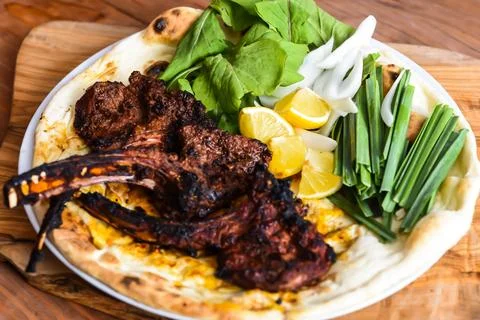 Lamb Chop or mutton chops with red sauce, bahraini bread tandoori nan, lime.. Stock Photos