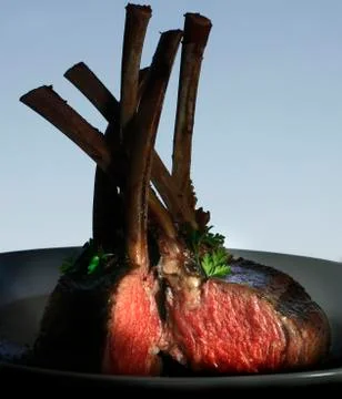 Lamb chops are seen ready to serve on a platter. Stock Photos