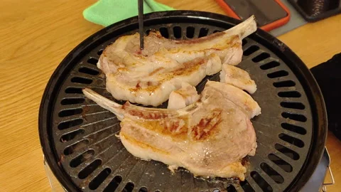 Lamb chops on a barbecue plate during a BBQ Stock Footage 232103077
