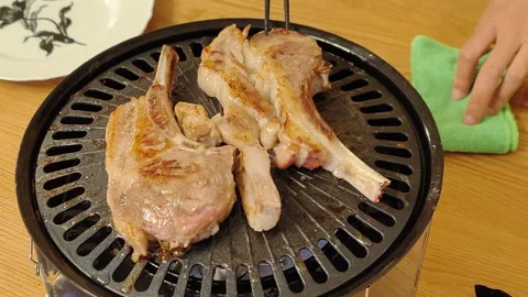 Lamb chops on a barbecue plate during a BBQ Stock Footage 232104972