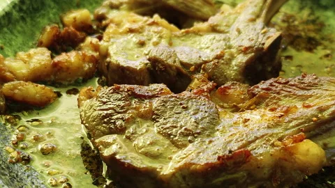 Lamb chops on a barbecue stone plate during a BBQ Stock Footage 232104628