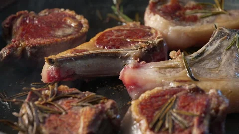 Lamb chops browning in pan with rosemary sprigs, developing seared crust on.. Video stock 313082001