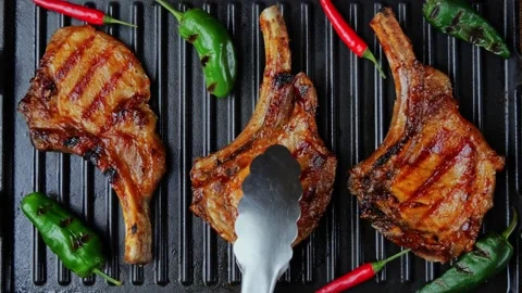 Lamb chops pork with bone on grill. Turn. Top view. Slow motion. Loin on ribs Stock Footage 262630399