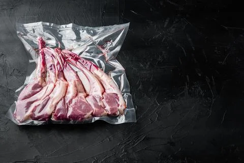 Lamb chops vacuumed for preservation or sous vide cooking, on black stone bac Stock Photos