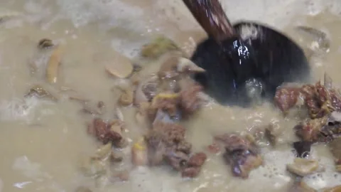 Lamb curry, cooking over fire, hot until boiling in large pan, authentic detail Stock Footage 293179109