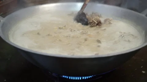 Lamb curry, cooking over fire, hot until boiling in large pan, authentic detail Stock Footage 293179232