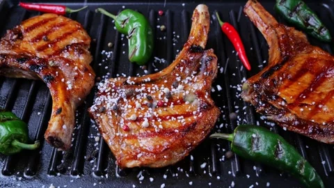 Lamb pork chops on grill sprinkle with salt and spices loin on ribs. Slow motion Stock Footage 263980475