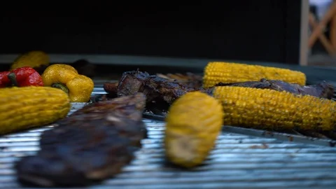 Lamb Ribs and Vegetables on a Rotating Grill, meat and corn on a barbecue, 4K Stock Footage 89694275