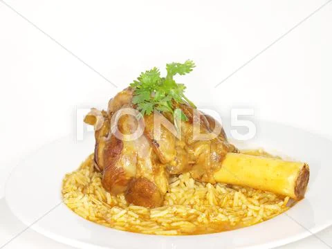 Lamb shank in juicy yellow rice Stock Photos