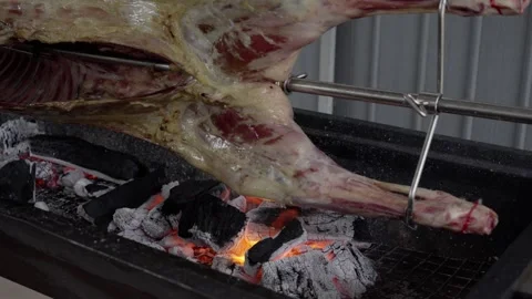 Lamb slowly roasting on a vertical spit 스톡 동영상 347930646