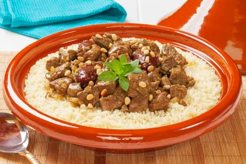 Lamb tagine with dates and pine nuts, served over couscous. Stock Photos