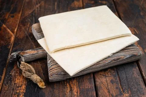 Laminated pastry dough sheets on rustic wood background, baking ingredient .. Stock Photos