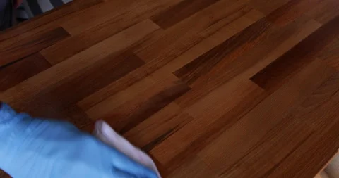 Laminated wood board protected using tung oil rubbed using piece of cloth Stock Footage 332649546