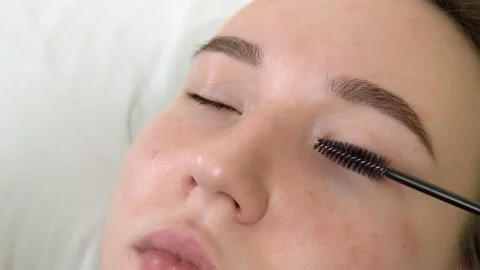 Before the lamination procedure, the eyelashes are combed with a long brush. Video stock 155669897