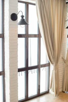 A lamp on the background of a window and a wall with curtains Stock Photos