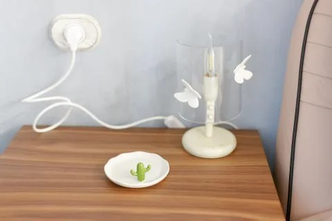 The lamp on the bedside table is plugged in. Stock Photos