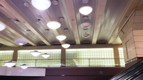 A lamp flickers on the ceiling above the escalator in the subway. Broken lamp Stock Footage 299930432