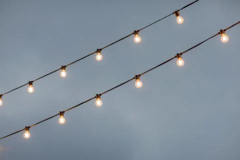 Lamp light bulbs on sky background. Christmas street mood Stock Illustration